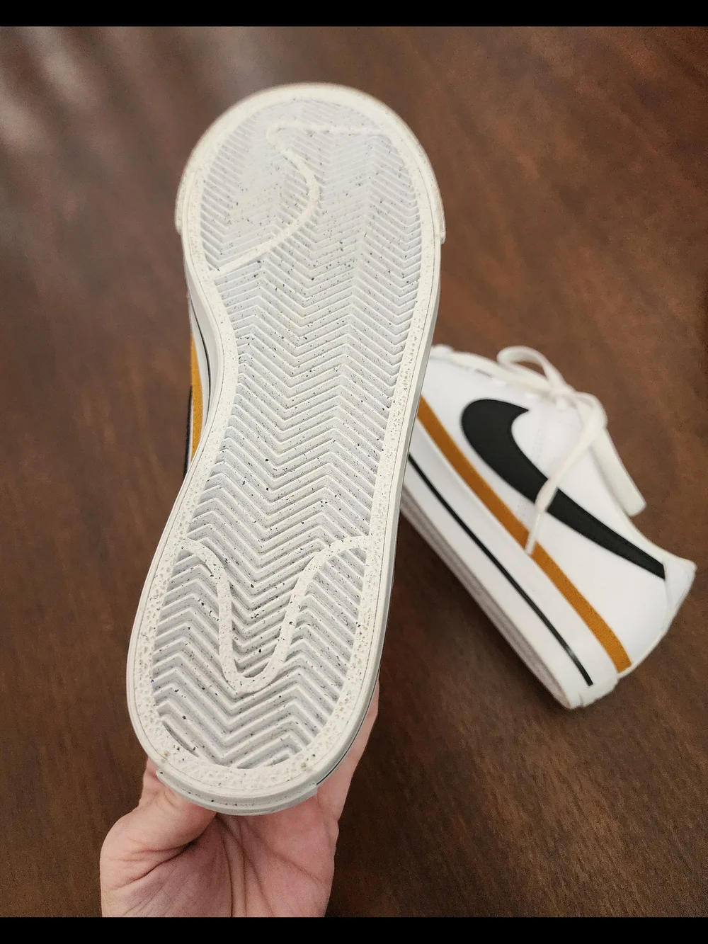 Nike White Low-Top Sneakers with Black Swoosh and Mustard Stripe
